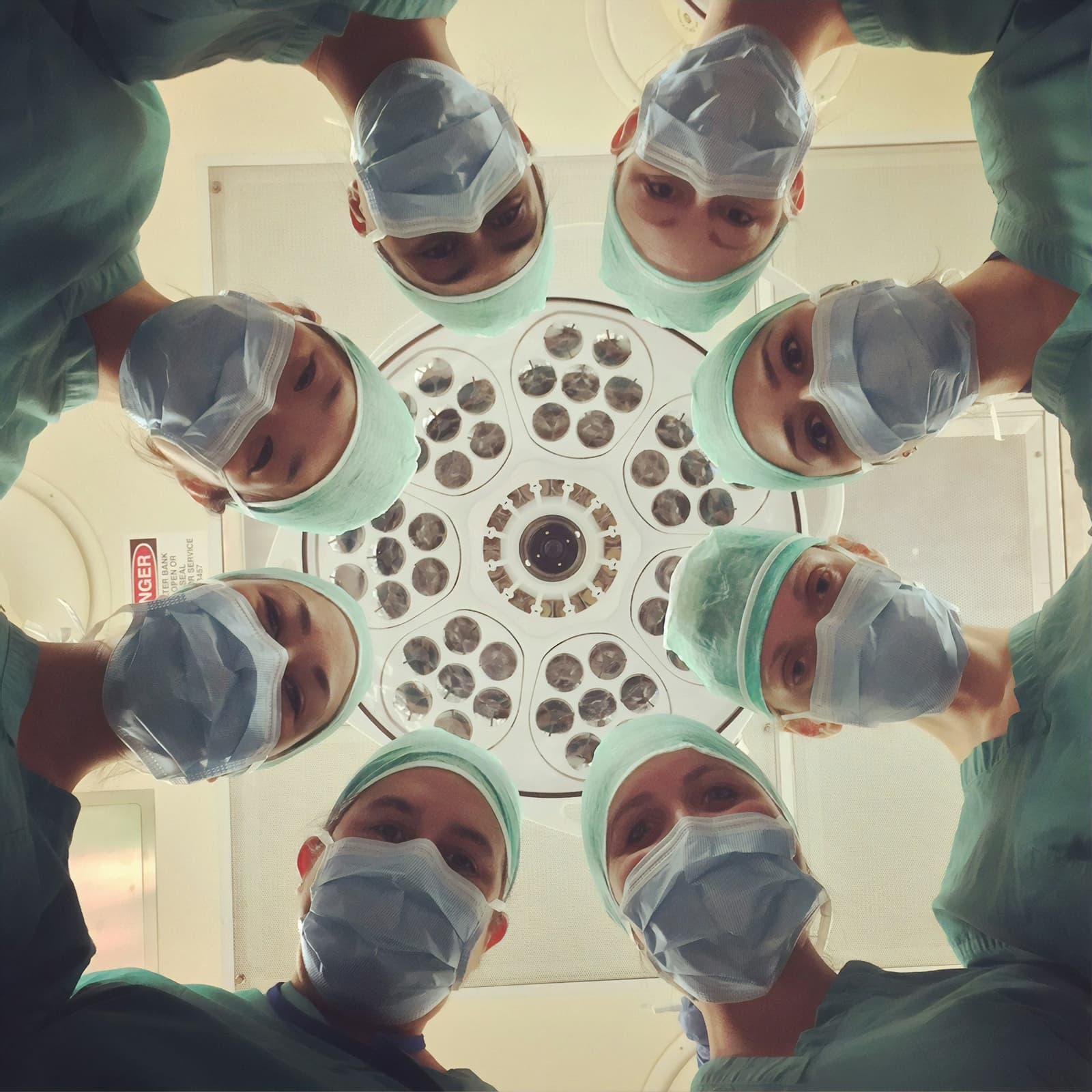 A surgical team working beneath an operating theatre light.