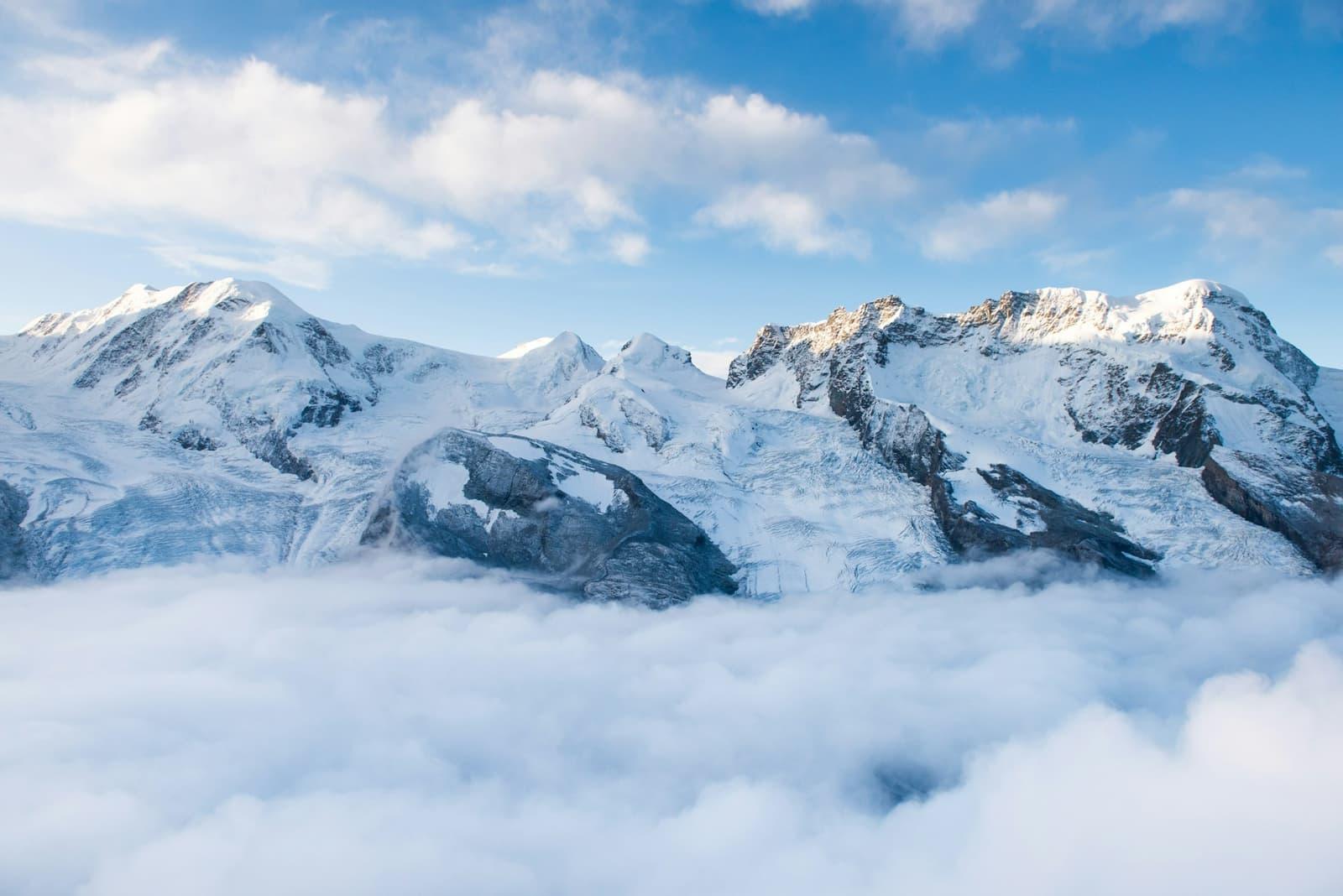 Snow-covered Swiss peaks rising above a sea of cloud.